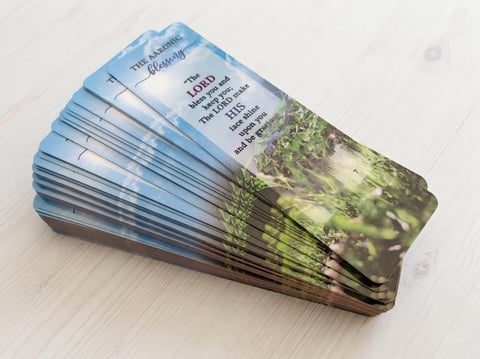 Stack of blue and green seed packets fanned out on a light wooden surface