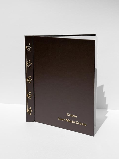 Dark brown hardcover book with decorative leaf spine design and Grazie text on cover
