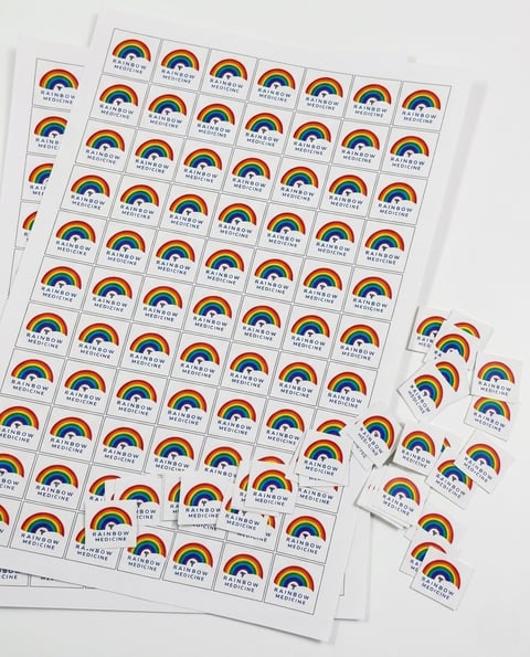 Sheets of rainbow stickers with text, displayed with individual stickers separated on a white background