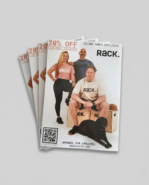 Stack of Rack Athletic apparel catalogs featuring models in branded clothing and 20% off promotional offer with QR code